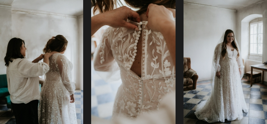 The bride's sister helps her put on her wedding dress.