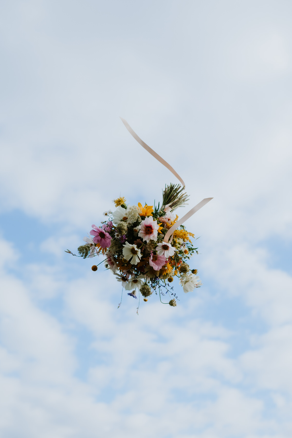 Creative capture of a wedding bouquet in flight.
