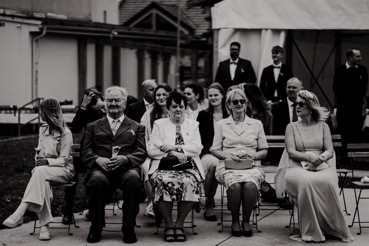 A snapshot of wedding guests during an outdoor ceremony.