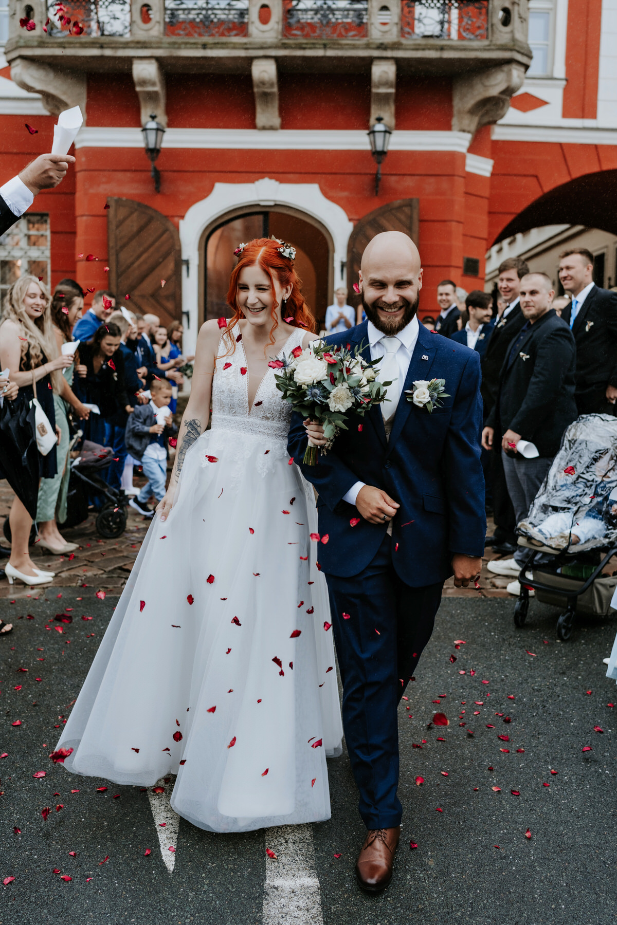 The bride and groom walk out of the ceremony as a married couple at their wedding Hradec Králové.