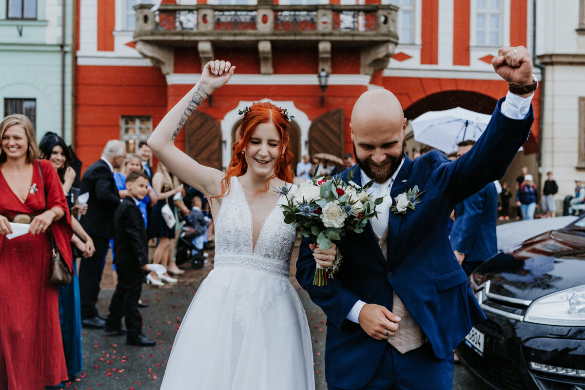 The newlyweds walk down the aisle and cheer.