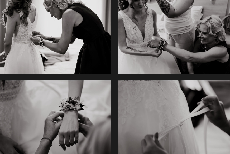 The bride's sister helps the bride put on her wedding dress.
